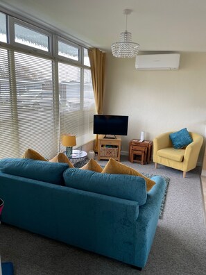 Relax in this stylish living room with a large sofa, flat-screen TV, and comfortable armchair.