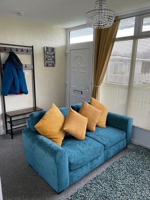 Relax in this inviting living room with a sofa, side table, and stylish rug.
