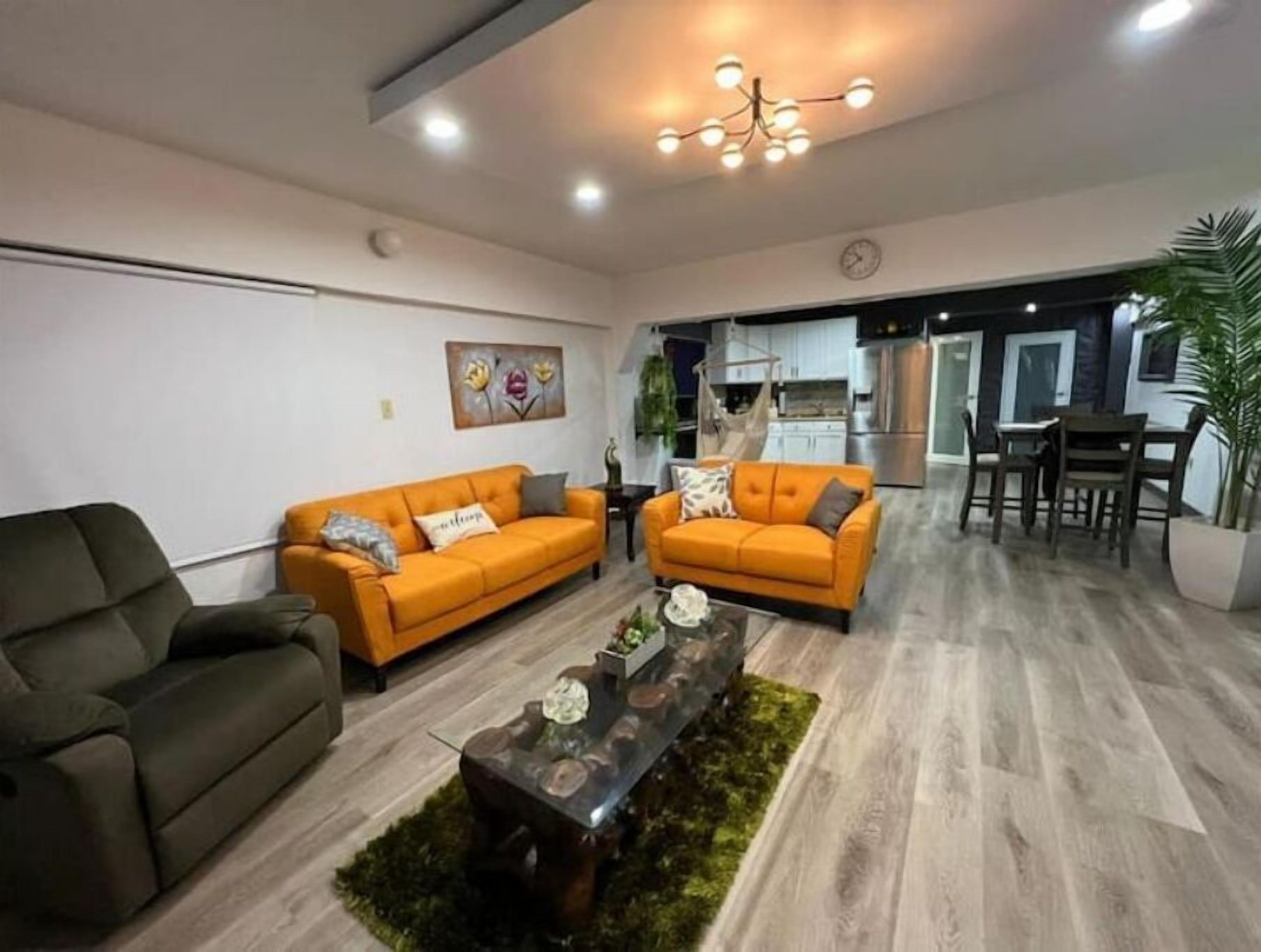 A modern living room with two sofas, a coffee table, and a dining area with chairs and a table.