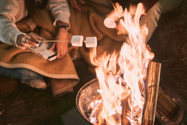 A person roasting marshmallows over a campfire. - Wabisabi Glamping (Bogotá)