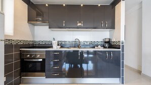 A modern kitchen with dark cabinetry, a stainless steel oven, and a tiled backsplash. - APARTMENT IN VIÑA DEL MAR - PLAYA DE LAS AMERICAS (Costa Adeje)
