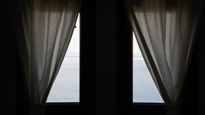 Two windows with sheer curtains, allowing a view of the sea. - Ira Charming apt with stunning view (Almyros)