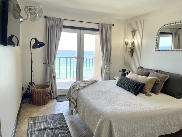 Une chambre à coucher avec un lit, une grande fenêtre avec des rideaux, une lampe de sol et un miroir avec des lumières.