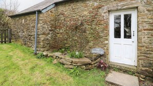 A stone house with a white door and a sign reading "THE BAKEHOUSE". - The Bake House (Bridgend)