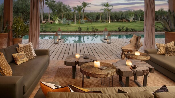 Un patio con piscina, mobiliario exterior y vistas a un campo de golf.
