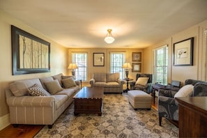 Relax in this stylish living room with a comfortable sofa set, matching ottoman, and wooden coffee table.
