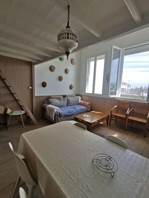 Relax in this spacious room with a large dining table, comfortable sofa, and a wooden bench.