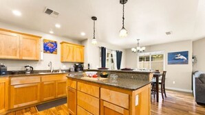 Una cocina moderna con armarios de madera, encimera de granito y una isla central.