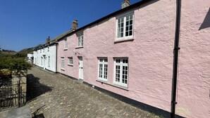 A row of pink buildings with stone-paved streets. - The Brewhouse Boscastle Harbour (Boscastle)