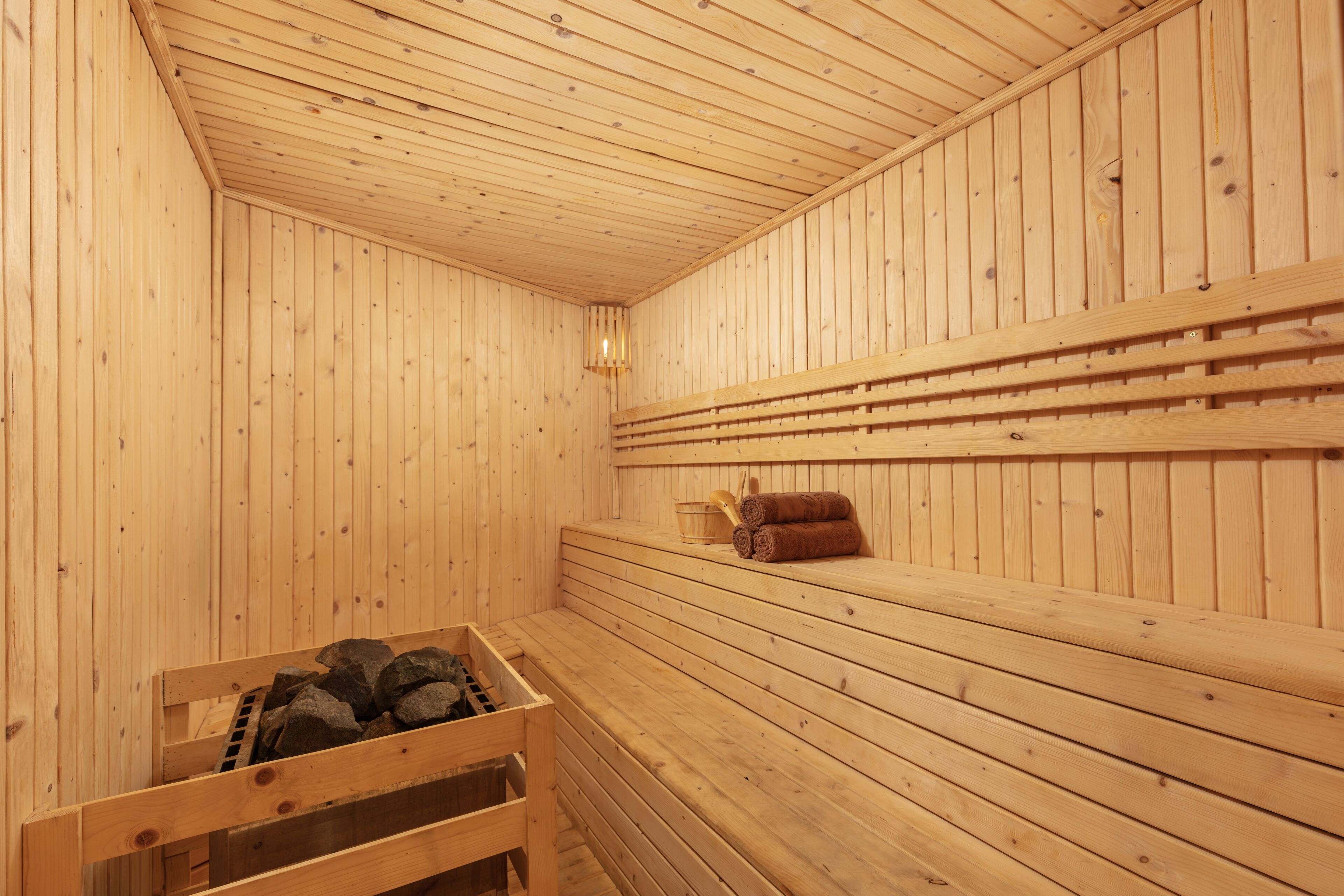 A wooden sauna with benches and a bench with a towel.