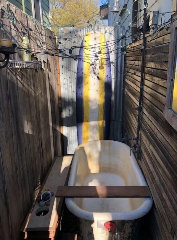 bathroom features a vintage bathtub and wooden plank.
