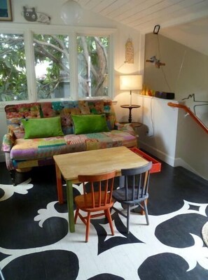 Relax in this inviting space with a vibrant sofa, two comfortable chairs, and a small wooden table.