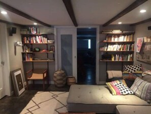 Relax in a stylish space with a comfortable sofa, wooden chair, and geometric-patterned rug.