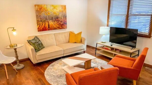 A living room with a sofa, two armchairs, a coffee table, a TV, and a painting on the wall. - Lovely Home! Great Location! The Nature House (Springfield)
