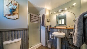 Ein Badezimmer mit Toilette, Waschbecken, Dusche und Handtuchhalter.