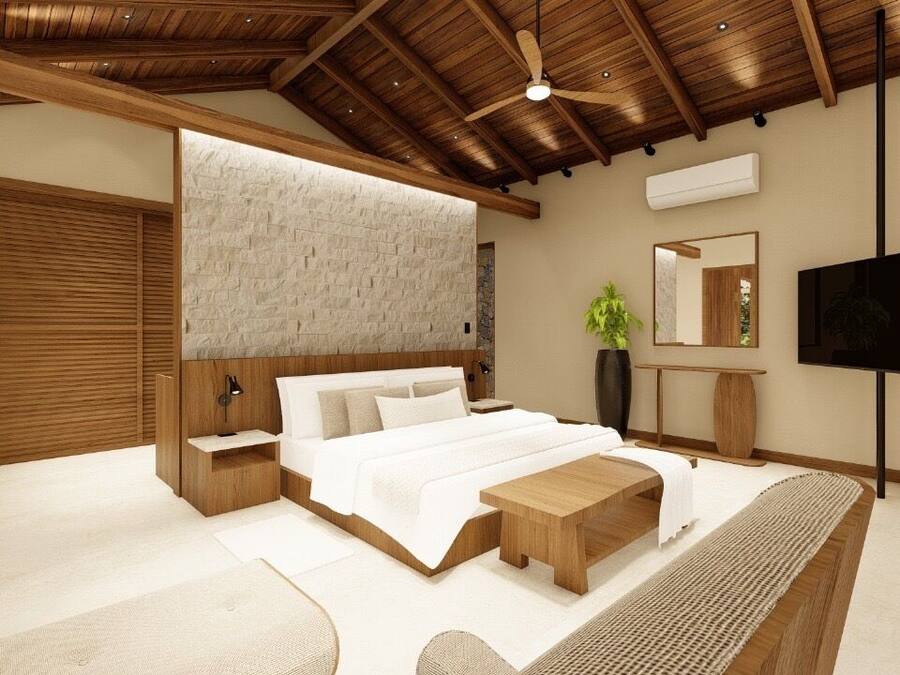 Un dormitorio moderno con techo de madera, una cama grande, televisor y pared de piedra.