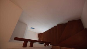 A staircase with wooden steps and a handrail, leading upwards in a modern building. - Holiday apartment Terraced house with private garden (Rosolina Mare)