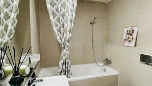 A bathroom with a bathtub, a toilet, and a sink with a mirror.