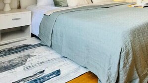 Une chambre à coucher avec un lit, une table de chevet, une lampe et un tableau encadré au mur.