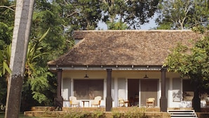 A two-story house with a tiled roof, a covered porch with chairs, and a well-maintained lawn. - Maison Couturier, San Rafael, a Member of Design Hotels (San Rafael)