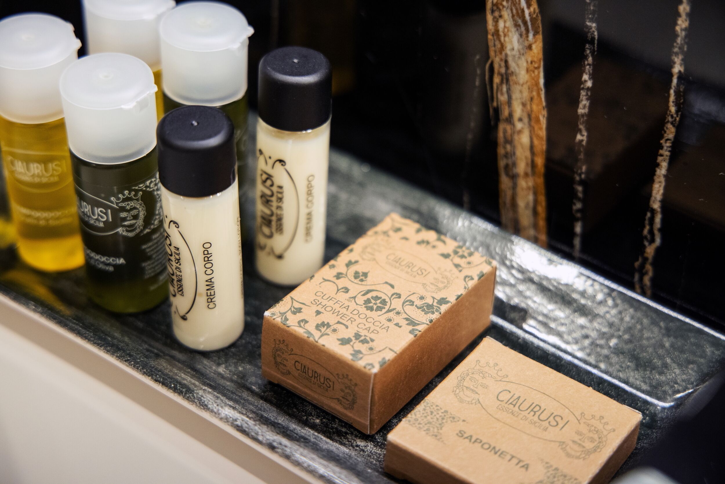 A shelf with various toiletries including bottles and boxes, likely in a hotel or similar establishment.