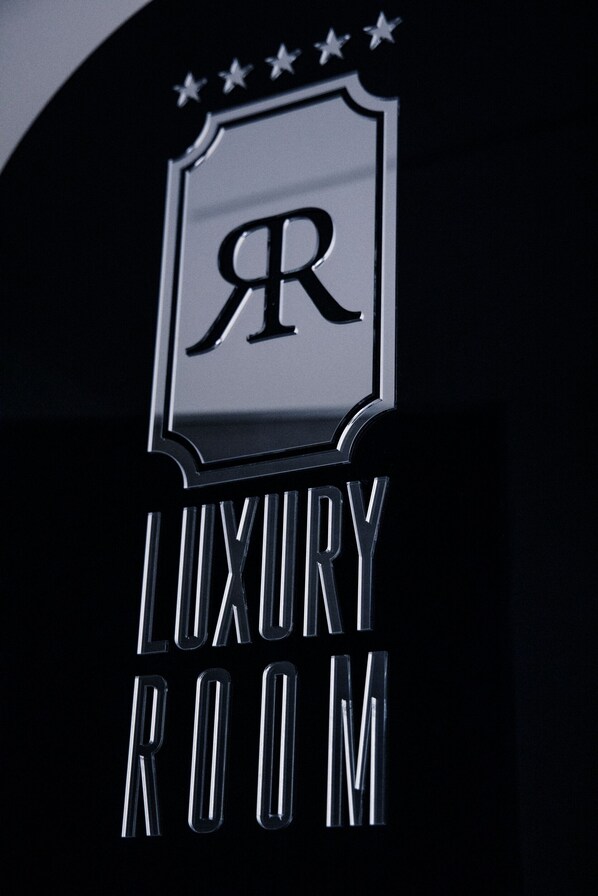 A sign with a shield emblem and the text "LUXURY ROOM".