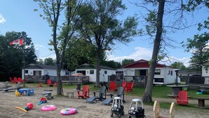 Un camping con varias casas móviles, mobiliario de exterior y equipo de juegos.