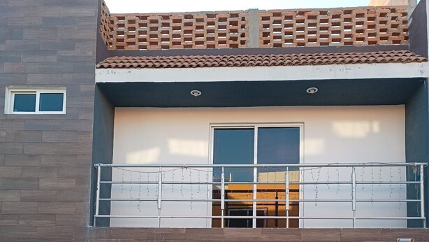 A two-story building with a car parked in front.