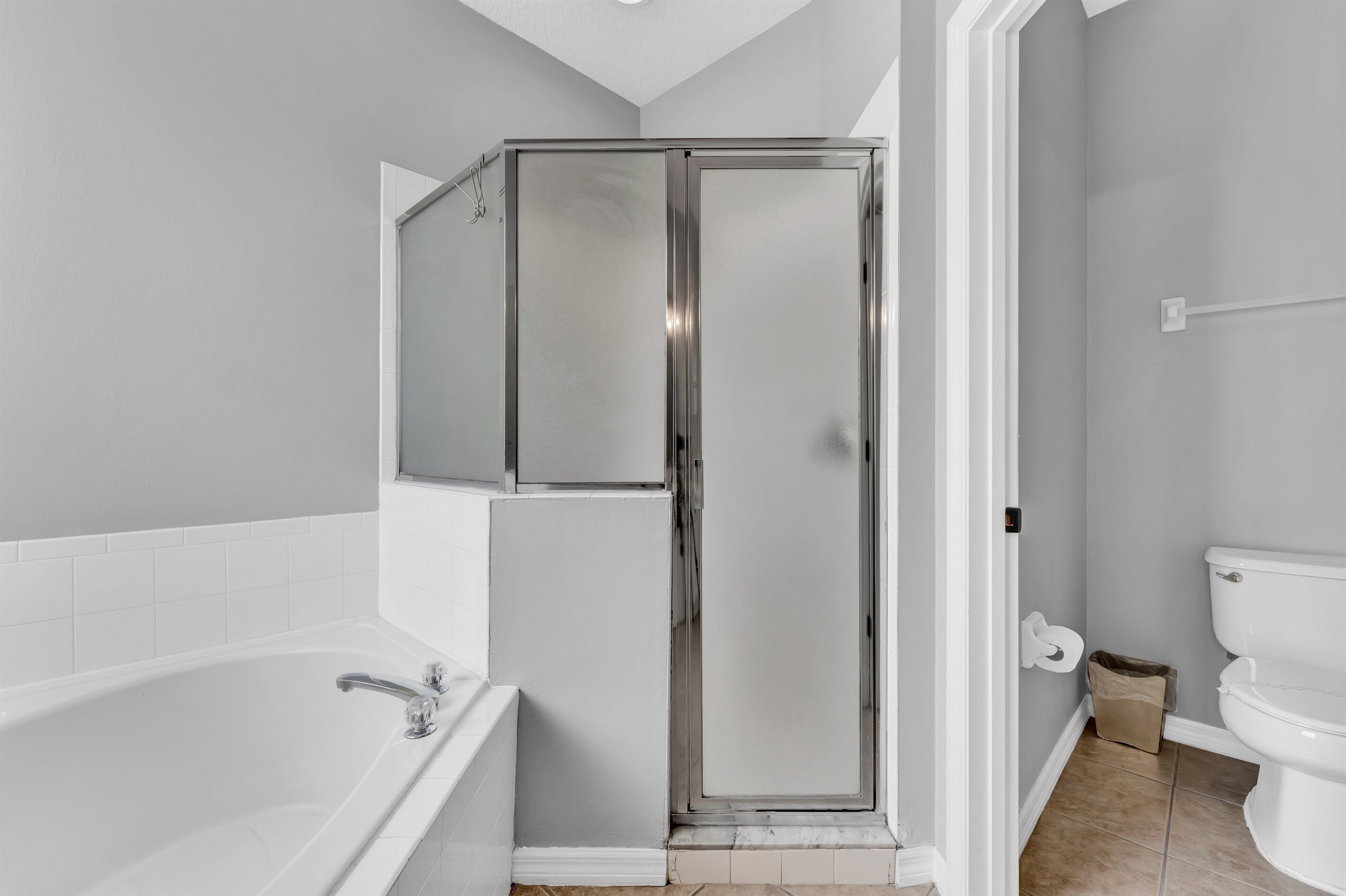 Un baño con cabina de ducha, bañera e inodoro.