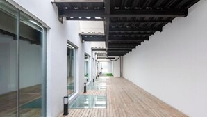 A corridor with glass walls, wooden flooring, and a ceiling with exposed beams. - Hongkou Silver Hotel (Tianjin)