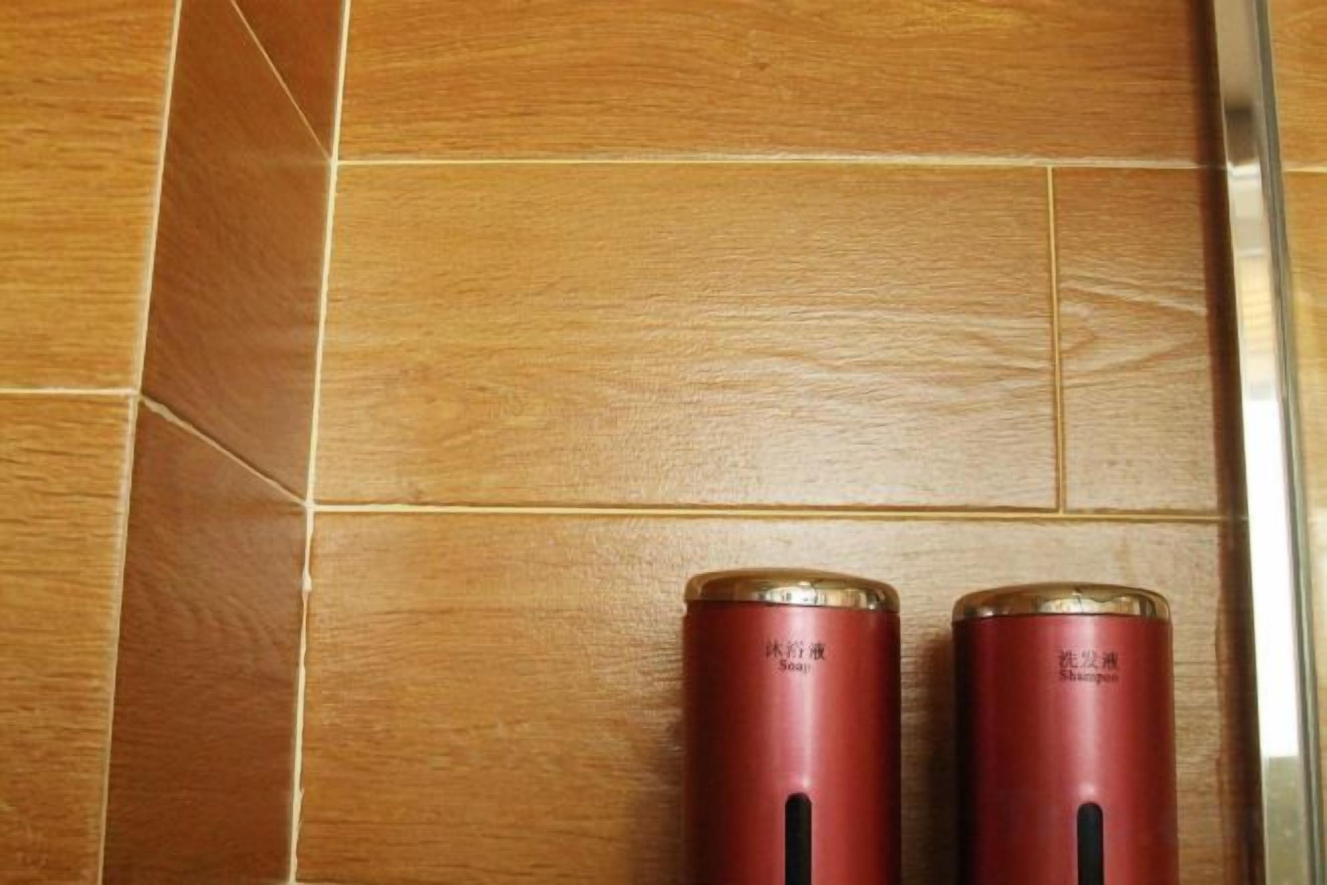 Two red cylindrical containers on a wooden floor.
