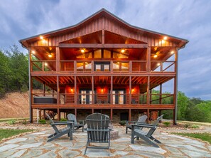 A two-story log cabin with a covered porch and outdoor seating area. - Panoramic Mountain Views (Sevierville)