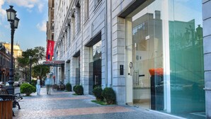 A cobblestone street with a modern building featuring large windows and a glass entrance.