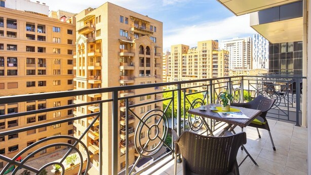 A balcony with wicker furniture, a table, and a chair.
