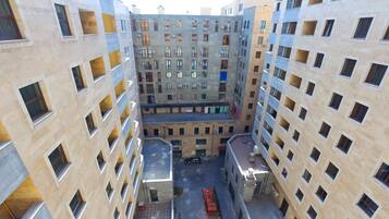 Un immeuble résidentiel à plusieurs étages doté d’une cour intérieure, de balcons et d’un espace de stationnement.