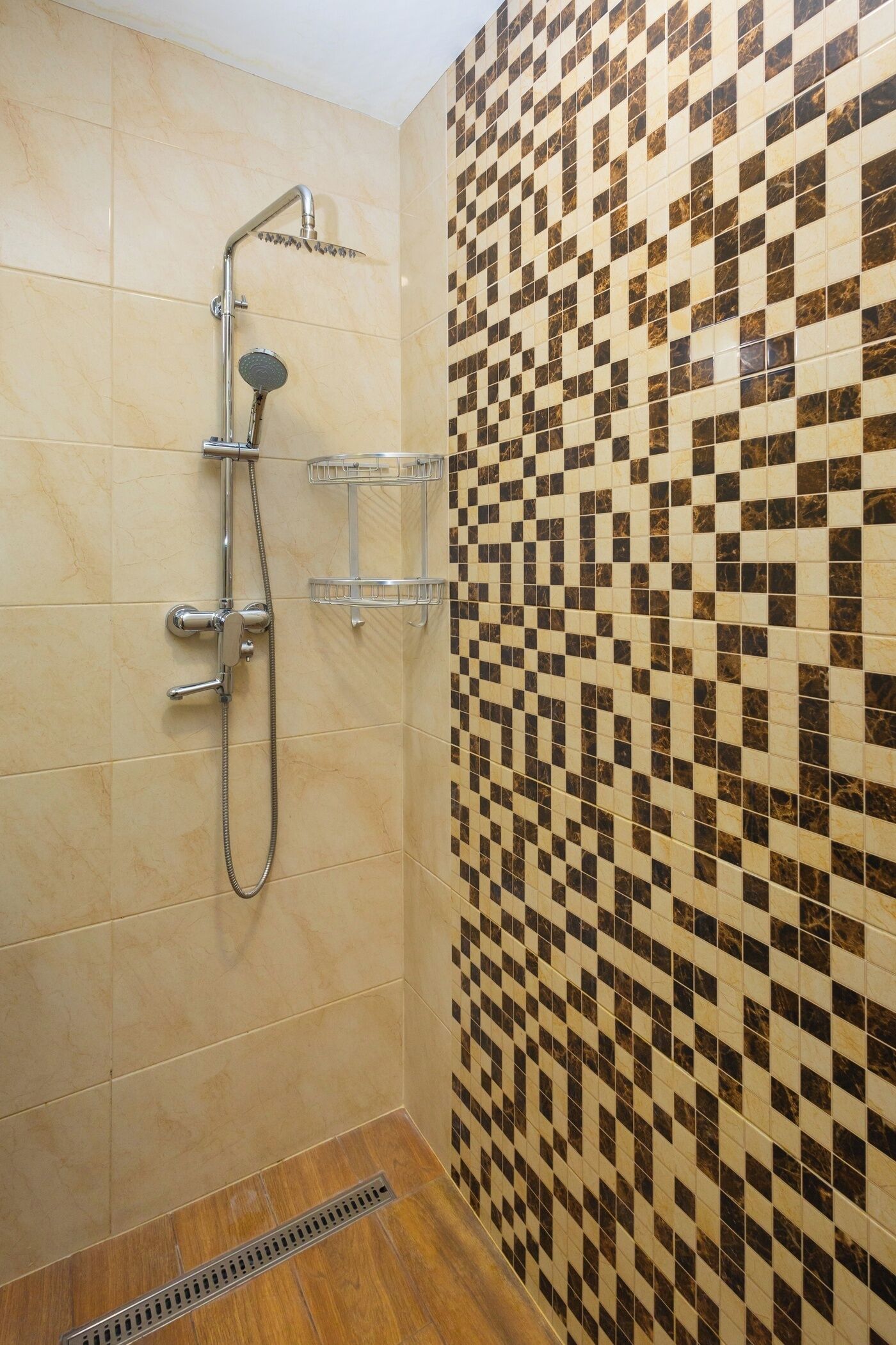 A shower with a handheld showerhead, a wall-mounted faucet, and a handheld showerhead.