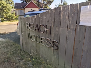Uma cerca de madeira com a inscrição 'BEACH ACCESS' entalhada.