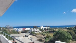 A residential area with modern buildings, a clear blue sky, and a view of the sea. - Gennadi Retreat - House 2 (Rhodes)