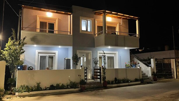 A two-story building with a balcony on the upper floor, a front entrance, and a staircase leading to the upper level. - Gennadi Retreat - House 2 (Rhodes)