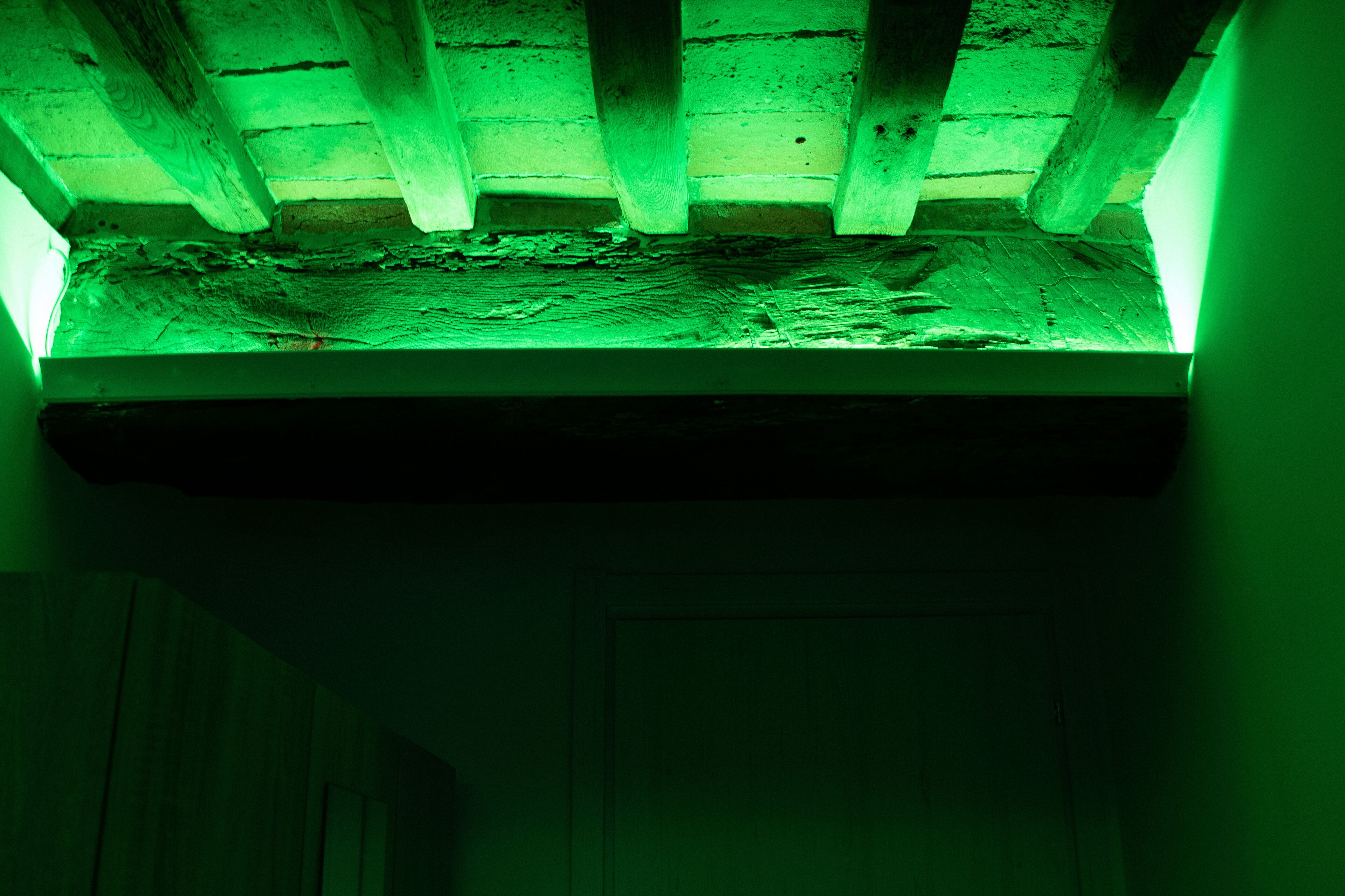 A room with a sloped ceiling and wooden beams.