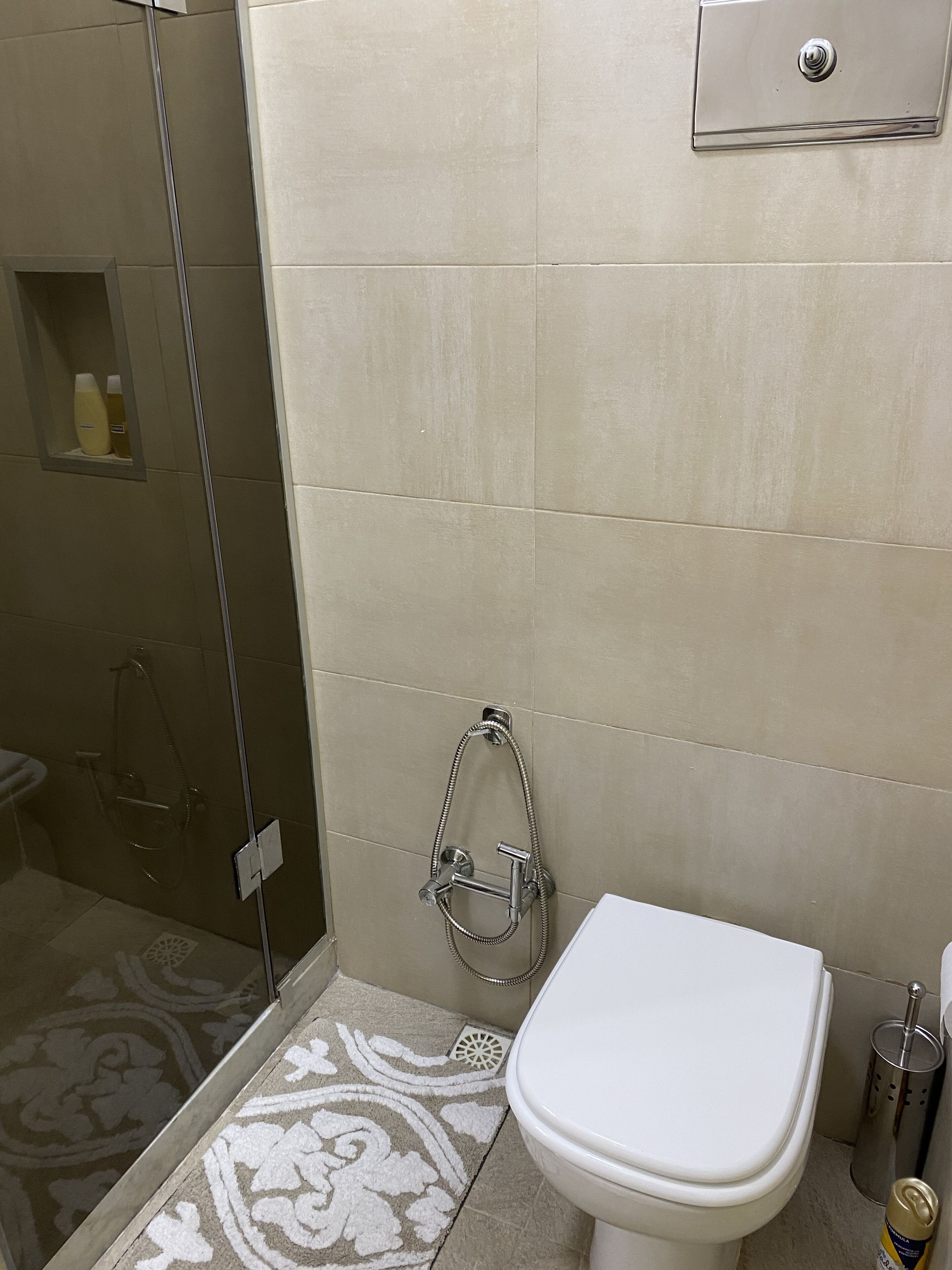 A bathroom with a glass-enclosed shower, a toilet, and a sink.