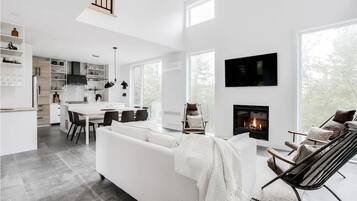 Cozy seating area with a fireplace, dining table, and kitchen.