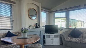 Una sala de estar con un sofá, una mesa de centro, un televisor y una chimenea.