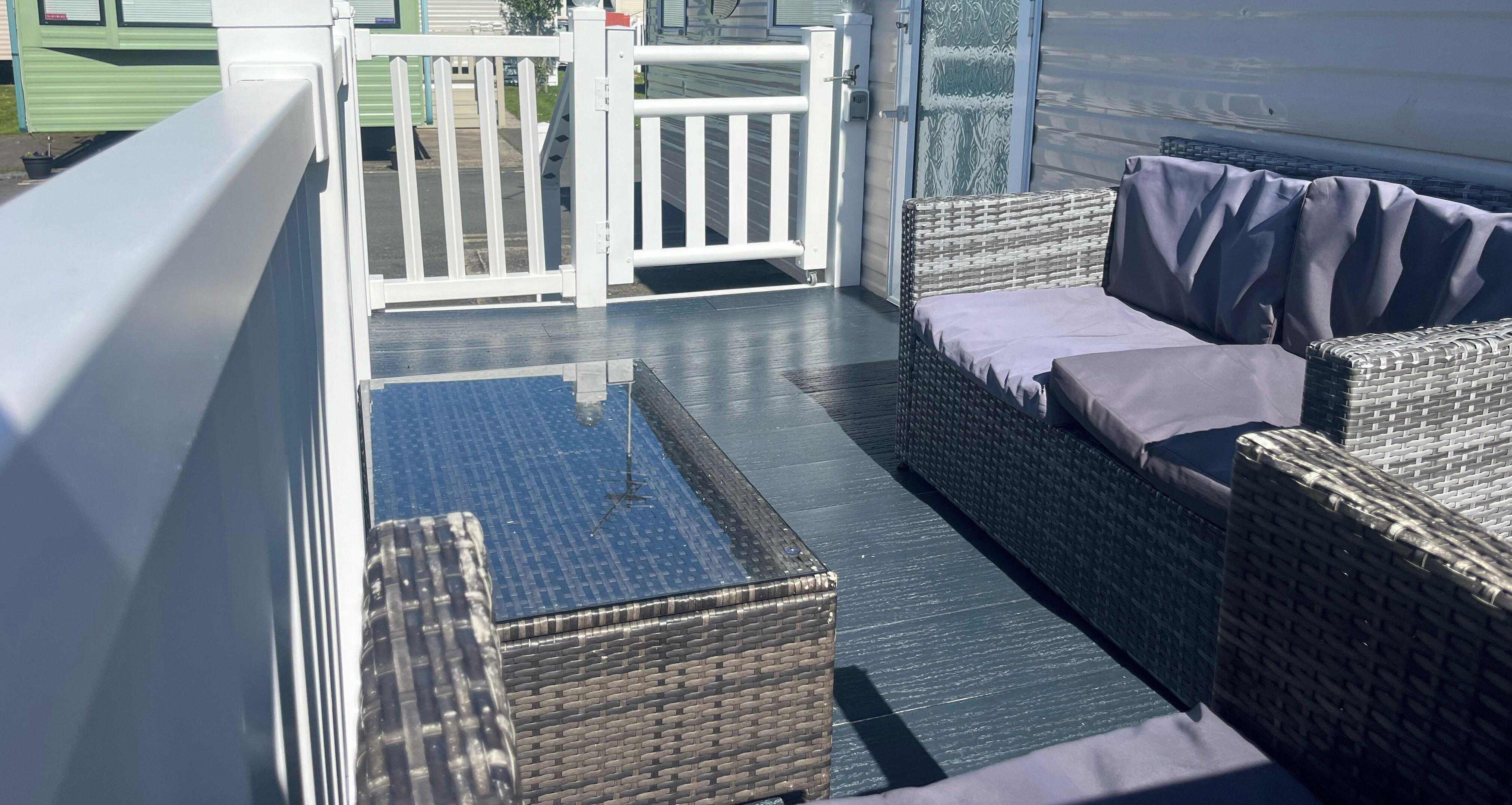 A balcony with wicker furniture and a metal gate.