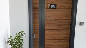 A wooden door with a number plate marked '101' and a keyhole. - Acacus Hotel (Kigali)