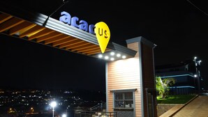 A building with a sign reading "acacia us" and a yellow location pin above it. - Acacus Hotel (Kigali)