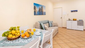 Ein Essbereich mit einem für das Frühstück gedeckten Tisch, einer Couch und einer Küchenzeile im Hintergrund.
