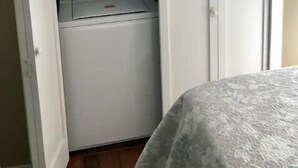A compact laundry room with a washer and dryer, a small shelf, and a door. - #139 Condo near large pool & shuttle to Gorge Amp-book separately (Quincy)