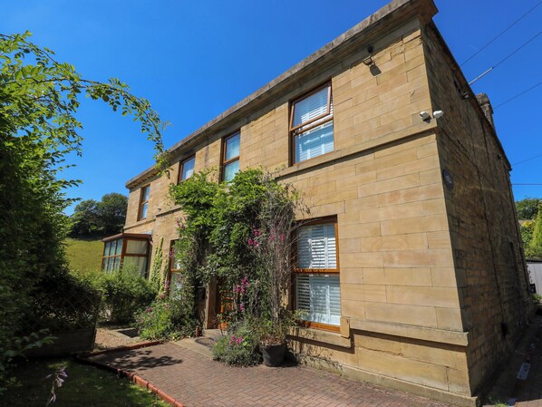 A two-story stone building with a brick pathway leading to the entrance. - The Old Post Office - Pet Friendly Group Stays in Holmfirth (Holmfirth)