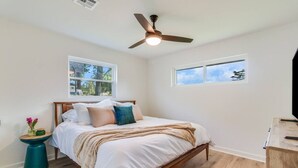 A bedroom with a bed, a ceiling fan, two windows, and a small side table. - KING Bed/Central Location/Fast wi-fi/5star listing (Lafayette)